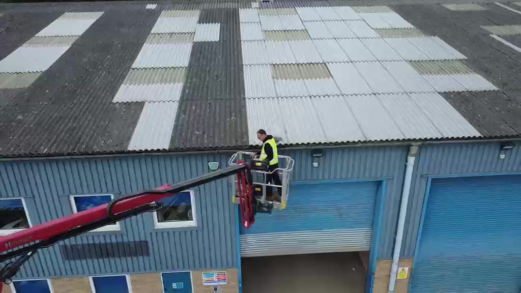 Operative working from the platform basket along an industrial unit roofline